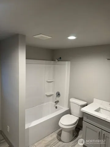 a white toilet sitting next to a bath tub