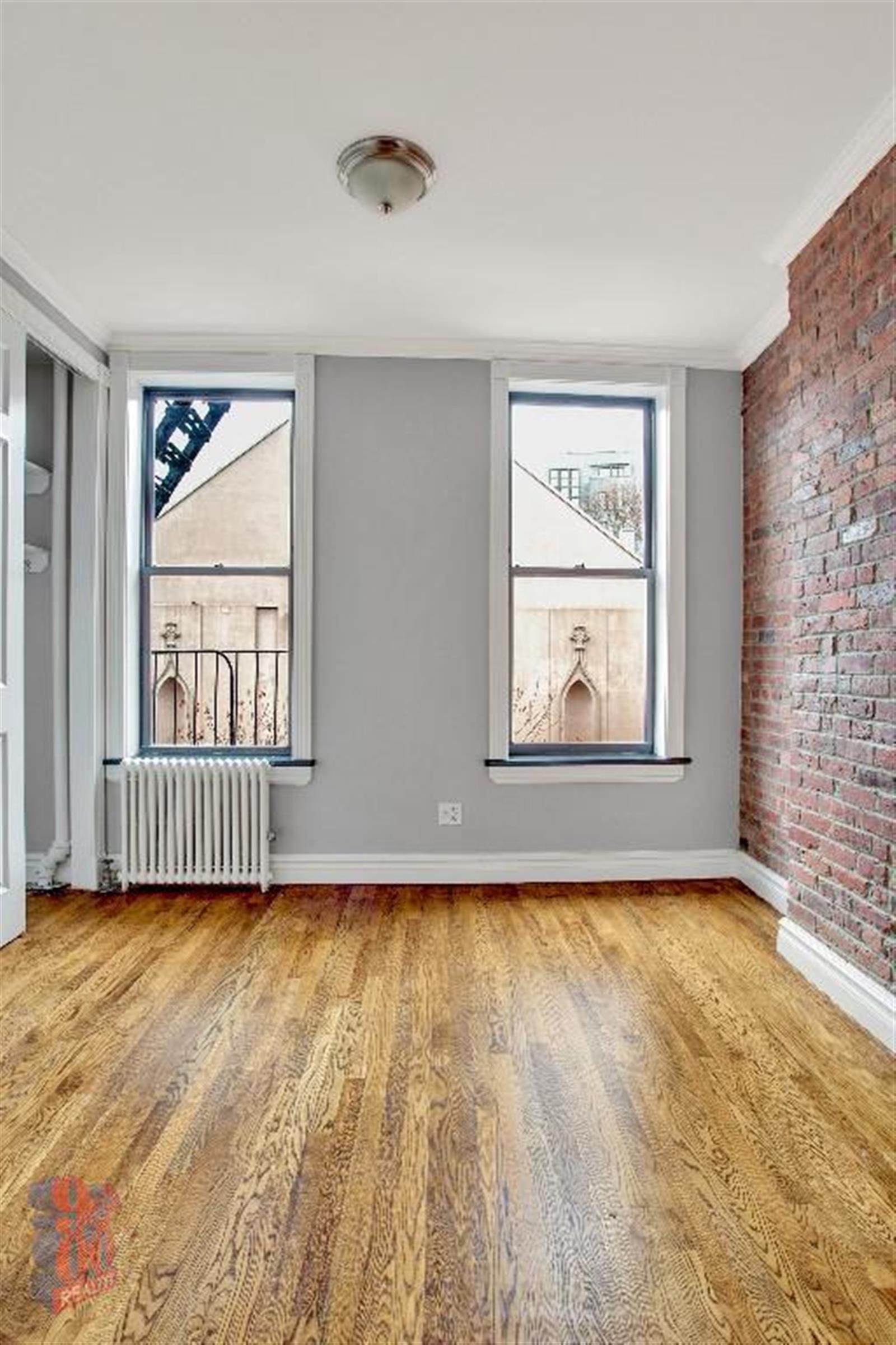 250 Mott Street, Unit 13 Manhattan, NY 10012 - Photo 2 of 5 a view of an empty room with glass door and wooden floor