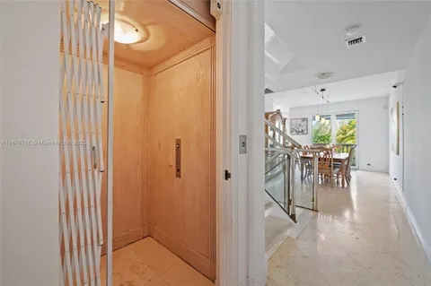 a view of a hallway with a dining table and chairs