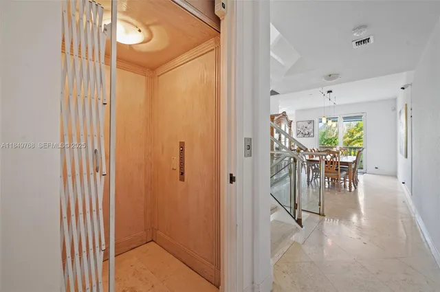 a view of a hallway with a dining table and chairs