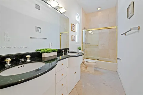 a bathroom with a double vanity sink toilet and shower