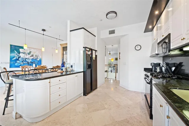 a kitchen with granite countertop a sink cabinets and stainless steel appliances