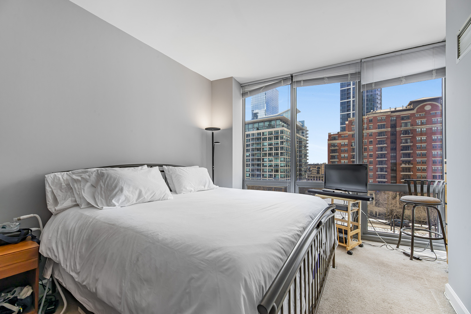 1235 South Prairie Avenue, Unit 706 Chicago, IL 60605 - Photo 7 of 15 a bedroom with a bed a table and a bookshelf