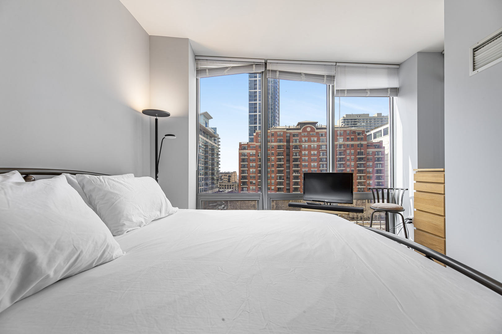 1235 South Prairie Avenue, Unit 706 Chicago, IL 60605 - Photo 8 of 15 a large bedroom with a bed and a fireplace