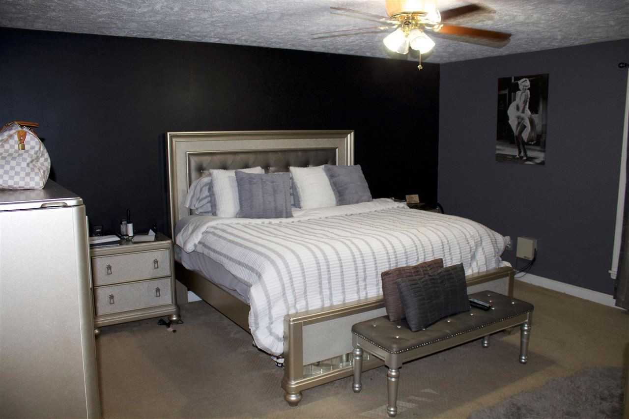 91 Collins Street Ripley, TN 38063 - Photo 8 of 18 a bedroom with a bed and a chandelier