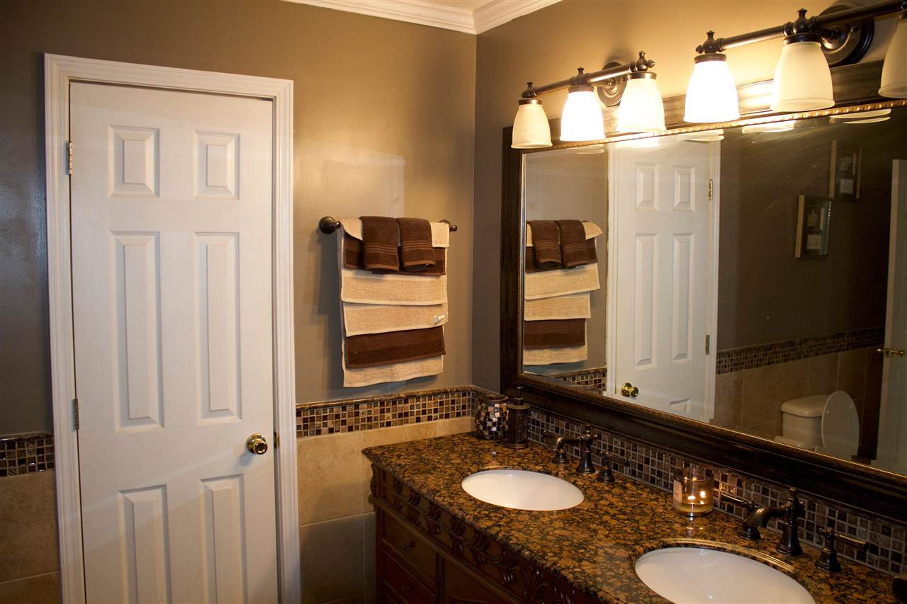 91 Collins Street Ripley, TN 38063 - Photo 9 of 18 a bathroom with a sink vanity granite and a mirror