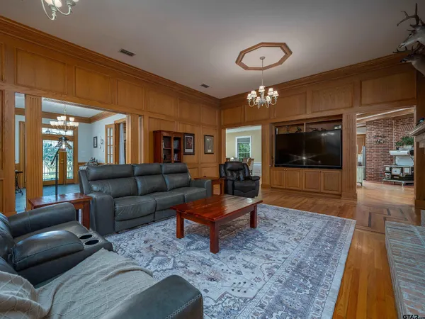 a kitchen with stainless steel appliances granite countertop wooden cabinets a refrigerator a sink a stove and a wooden floors