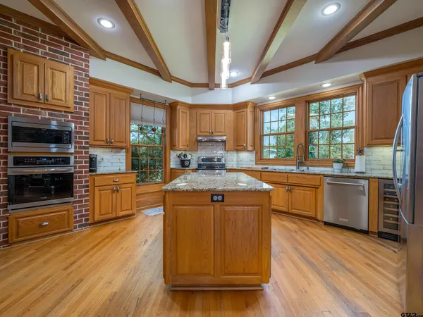 a kitchen with stainless steel appliances granite countertop a stove a sink and a microwave