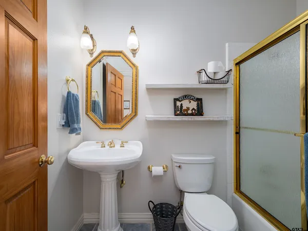 a bathroom with a toilet sink and mirror