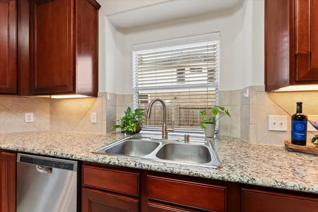 a kitchen with granite countertop a sink a stove and cabinets