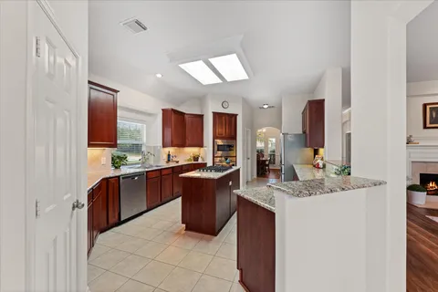 a kitchen with stainless steel appliances granite countertop a sink stove and cabinets