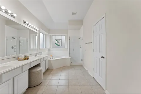 a large white kitchen with a sink and dishwasher with white cabinets
