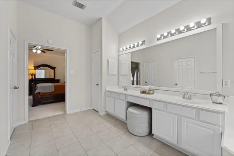 a en suite bathroom with a double vanity sink and a mirror