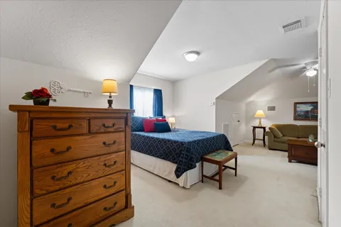 a spacious bedroom with a bed a couch and dresser