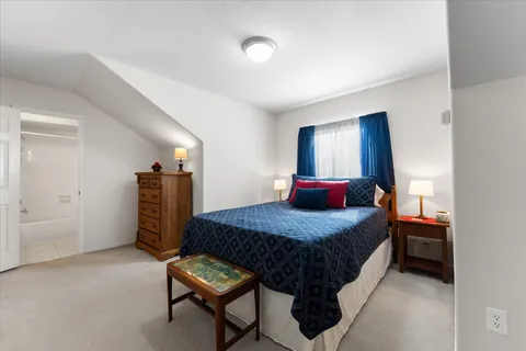 a bedroom with a bed and a refrigerator