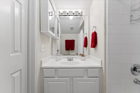 a bathroom with a sink vanity and mirror