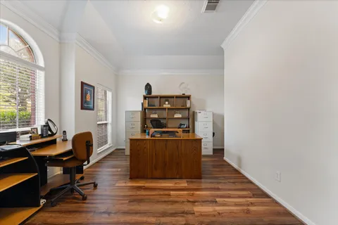 a view of a workspace with furniture and a window