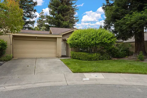a side view of a house with a yard and garage