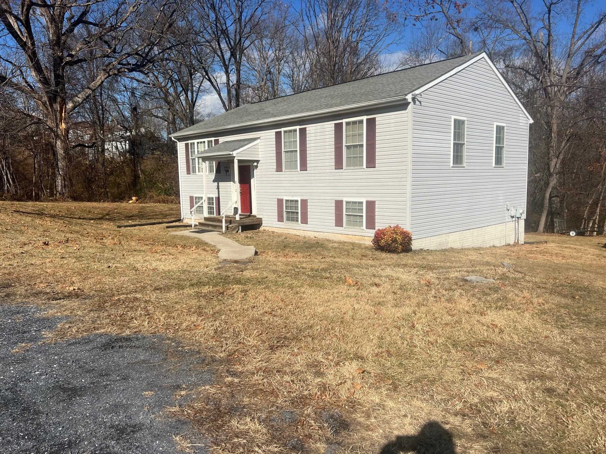 a view of a house with backyard and trees