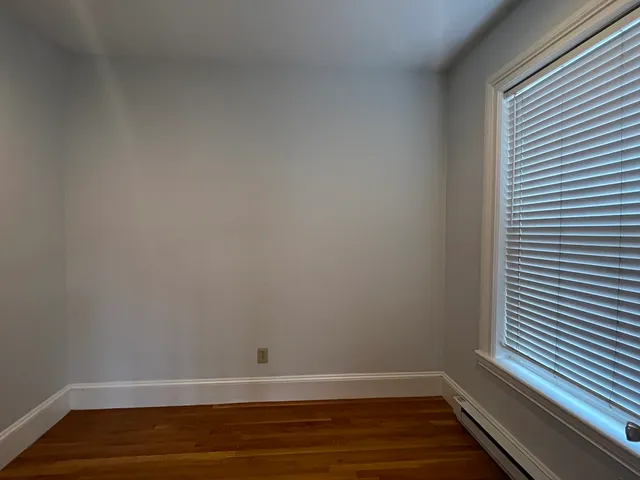 a view of a room with wooden floor and a window