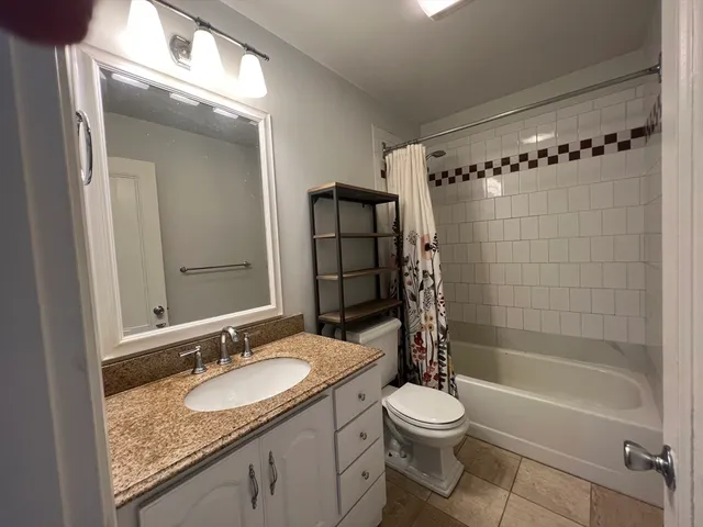 a bathroom with a granite countertop sink toilet and shower
