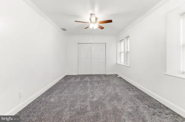 an empty room with a window and a ceiling fan