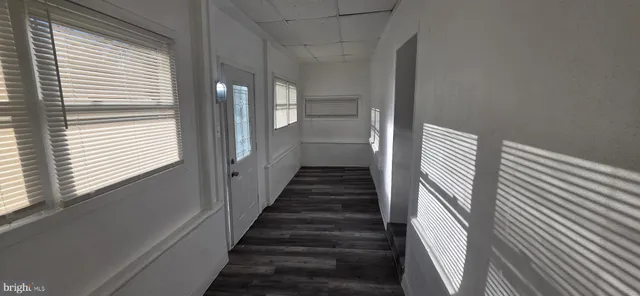 a view of a hallway with wooden floor and windows