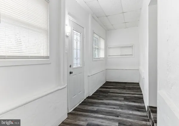 a view of a hallway with wooden floor and entryway