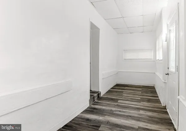 a view of a room with wooden floor and white walls
