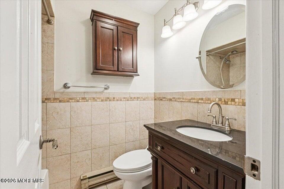 70 Overlook Way, Unit E Manalapan, NJ 07726 - Photo 16 of 20 a bathroom with a granite countertop toilet sink and mirror