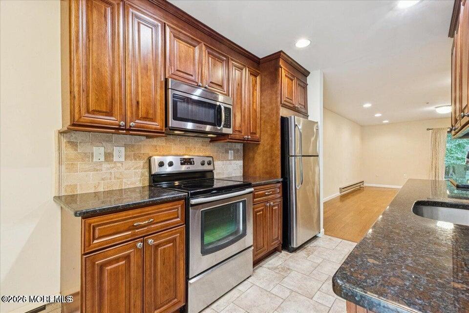 70 Overlook Way, Unit E Manalapan, NJ 07726 - Photo 4 of 20 a kitchen with stainless steel appliances granite countertop a refrigerator stove top oven and sink