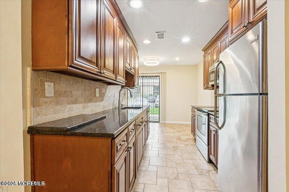 70 Overlook Way, Unit E Manalapan, NJ 07726 - Photo 5 of 20 a kitchen with stainless steel appliances granite countertop a refrigerator and a sink