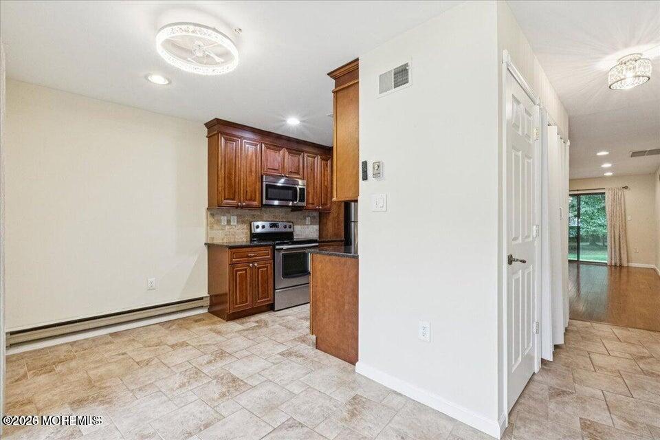 70 Overlook Way, Unit E Manalapan, NJ 07726 - Photo 7 of 20 a kitchen with stainless steel appliances a refrigerator and a stove top oven