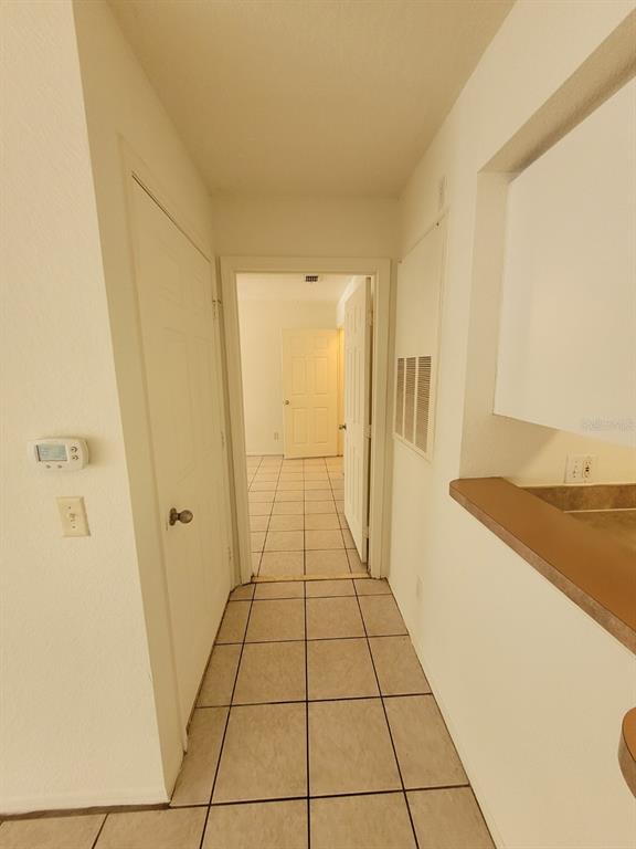 36037 Deer Creek Drive, Unit 102 Zephyrhills, FL 33541 - Photo 11 of 44 a view of a hallway with wooden floor and a bathroom