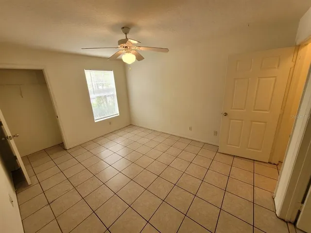 a view of an empty room and chandelier fan