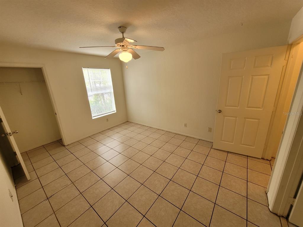 36037 Deer Creek Drive, Unit 102 Zephyrhills, FL 33541 - Photo 13 of 44 a view of an empty room and chandelier fan