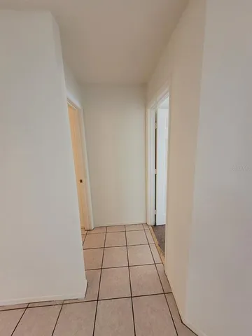 an empty room with windows and chandelier fan