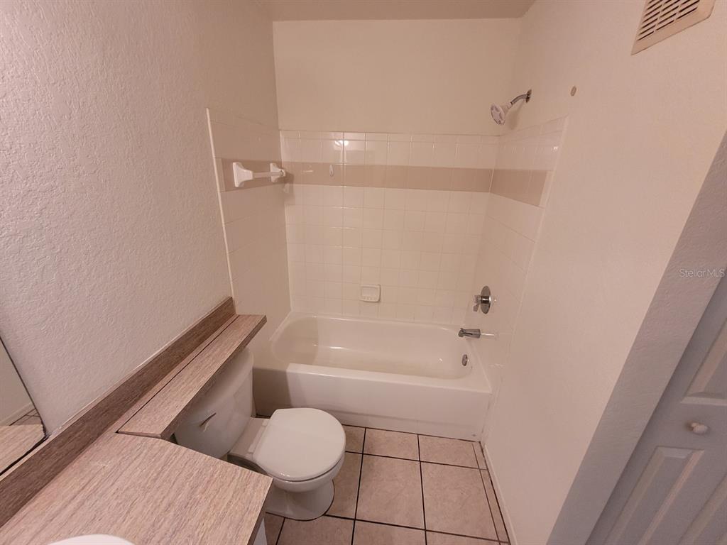 36037 Deer Creek Drive, Unit 102 Zephyrhills, FL 33541 - Photo 25 of 44 a bathroom with a toilet and a bathtub