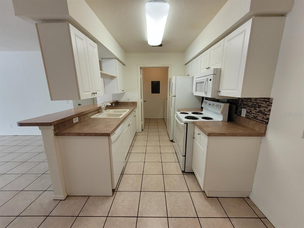 36037 Deer Creek Drive, Unit 102 Zephyrhills, FL 33541 - Photo 7 of 44 a kitchen with stainless steel appliances granite countertop a sink stove and cabinets