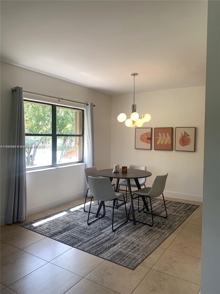 11533 Southwest 109th Road, Unit 21G Miami, FL 33176 - Photo 11 of 39 a view of a dining room with furniture and chandelier