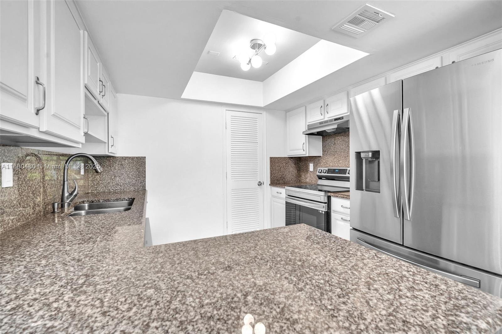 11533 Southwest 109th Road, Unit 21G Miami, FL 33176 - Photo 14 of 39 a kitchen with stainless steel appliances granite countertop a refrigerator a stove and a sink