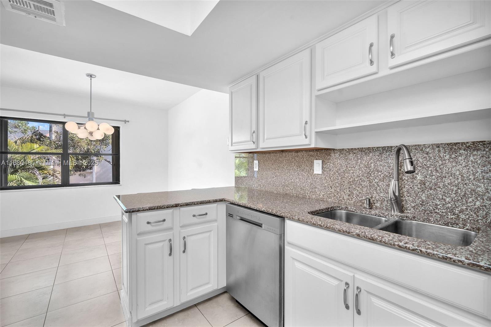 11533 Southwest 109th Road, Unit 21G Miami, FL 33176 - Photo 15 of 39 a kitchen with white cabinets and a sink