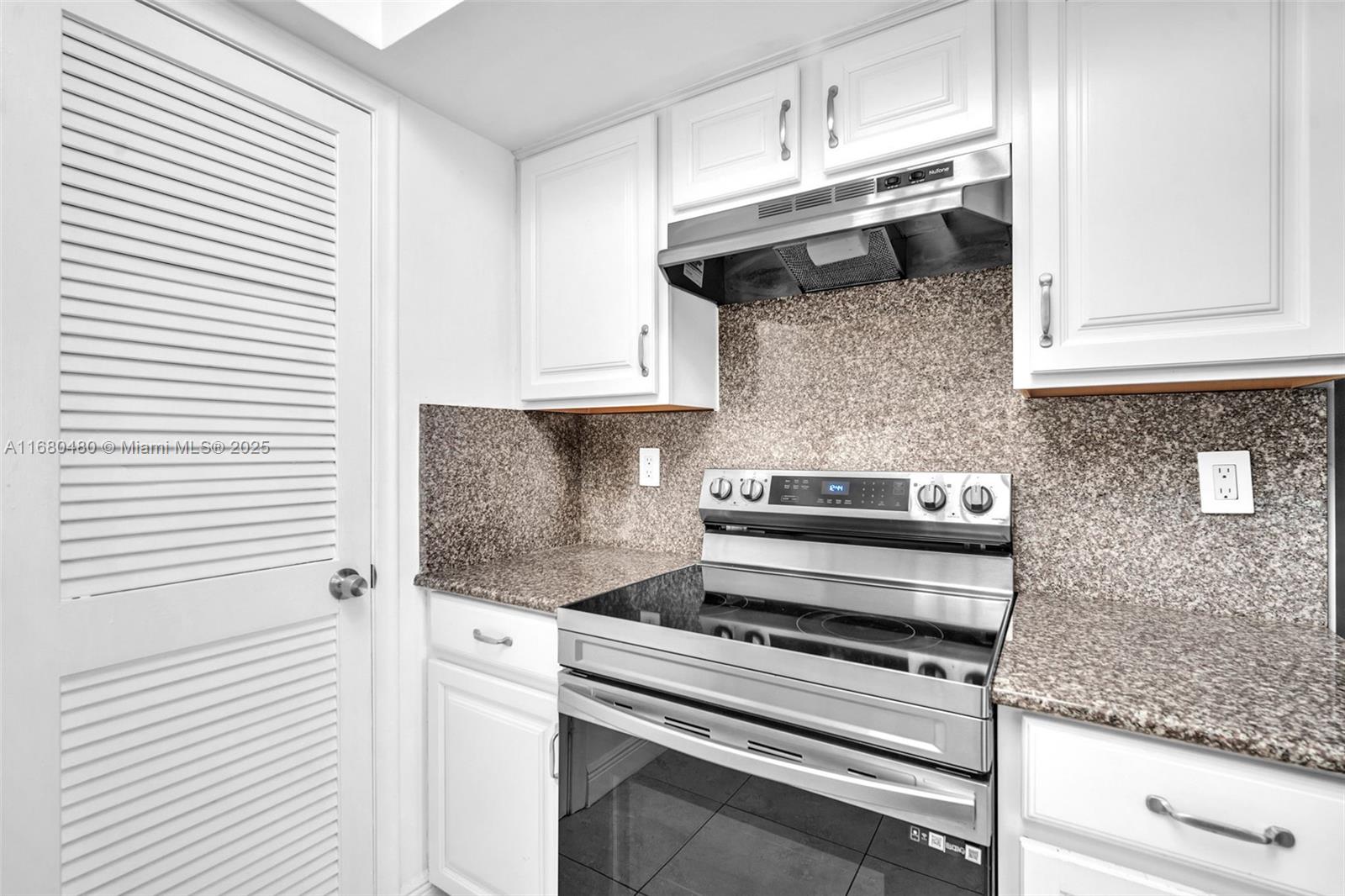 11533 Southwest 109th Road, Unit 21G Miami, FL 33176 - Photo 17 of 39 a kitchen with stainless steel appliances granite countertop a stove and a white cabinets