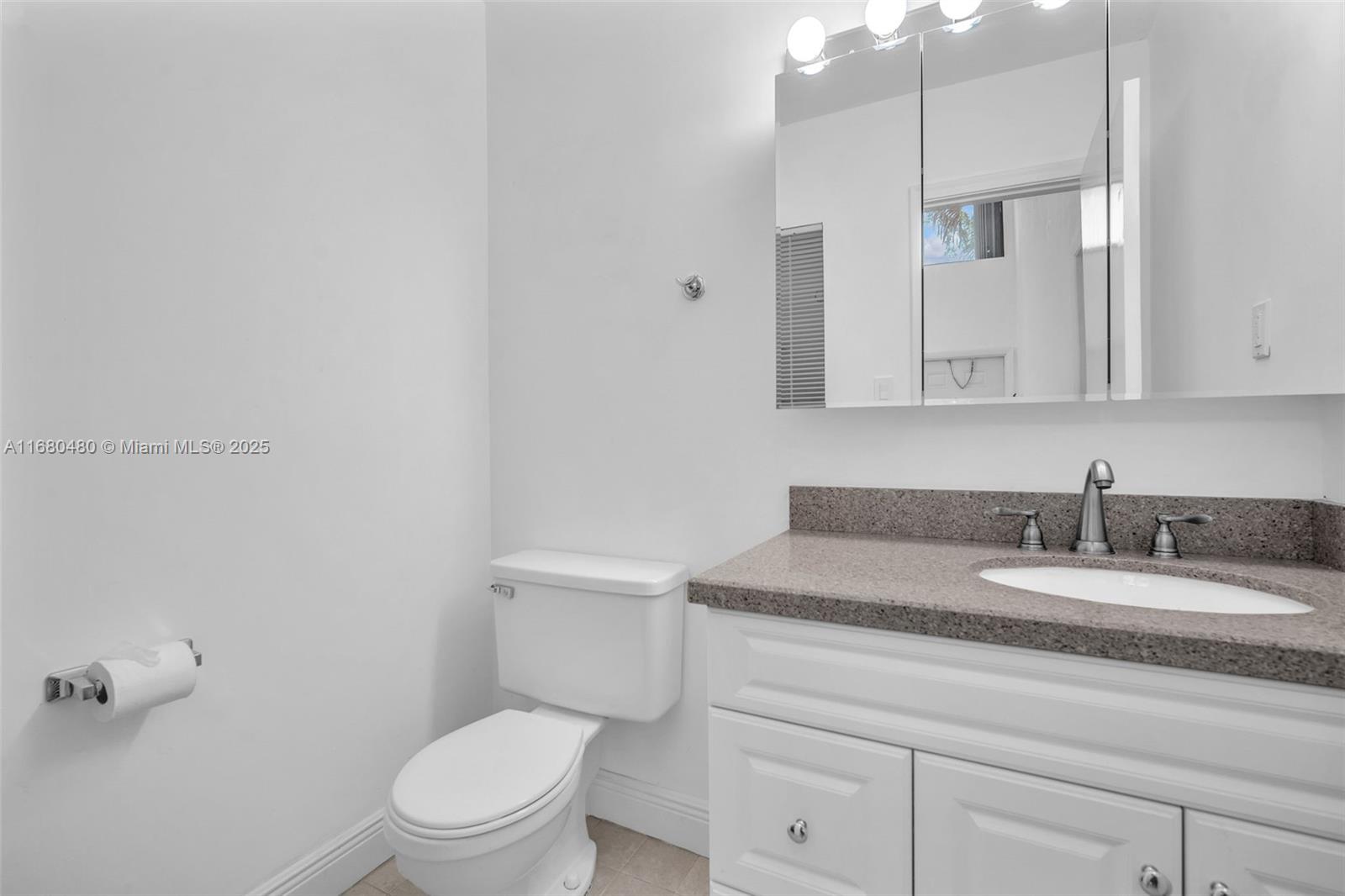 11533 Southwest 109th Road, Unit 21G Miami, FL 33176 - Photo 32 of 39 a bathroom with a granite countertop toilet sink mirror and vanity
