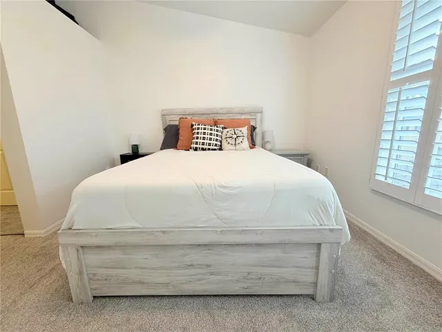 a spacious bedroom with a bed and a window