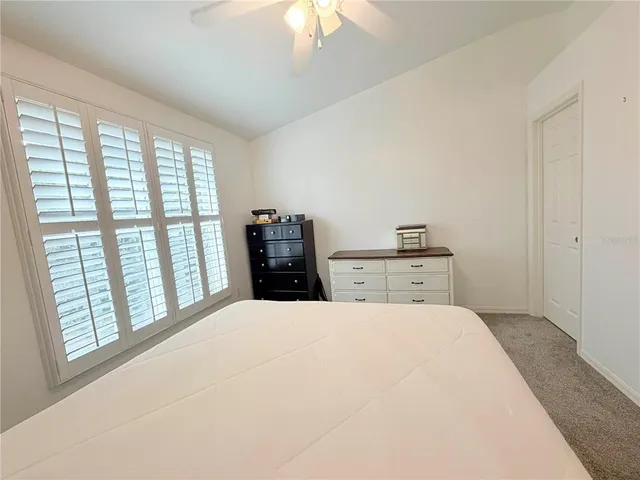 a large white bed in a bedroom next to a window