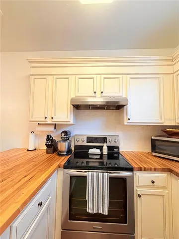a kitchen with a stove and a white cabinets