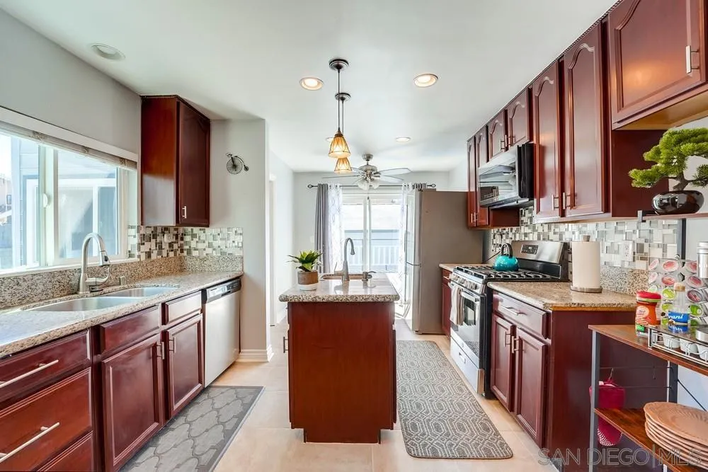 9055 Rosedale Drive Spring Valley, CA 91977 - Photo 1 of 38 a kitchen with kitchen island granite countertop a sink stove and cabinets