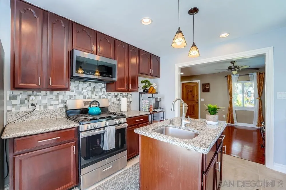 9055 Rosedale Drive Spring Valley, CA 91977 - Photo 13 of 38 a kitchen with granite countertop stainless steel appliances a stove sink microwave and cabinets