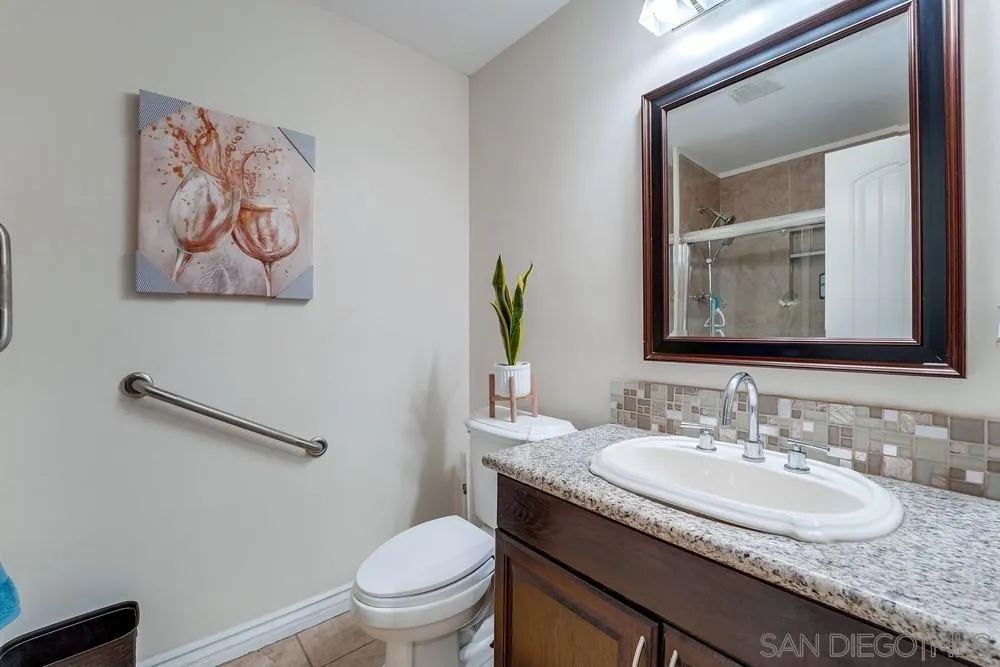 9055 Rosedale Drive Spring Valley, CA 91977 - Photo 17 of 38 a bathroom with a granite countertop sink mirror and toilet